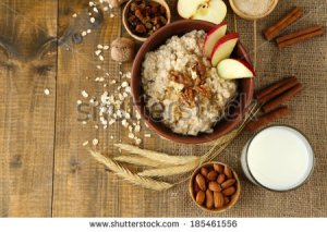 stock-photo-tasty-oatmeal-with-nuts-and-apples-on-wooden-table-185461556